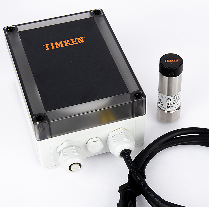timken-wireless-sensor-and-enclosed-gateway-863x871 A woman wearing safety glasses assembles part at a work bench