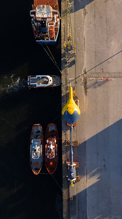 CorPower C4 on a dock, next to the ocean.